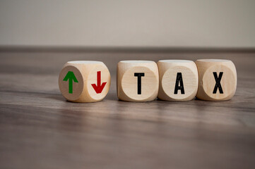 Cubes or dice with tax up and down on wooden background
