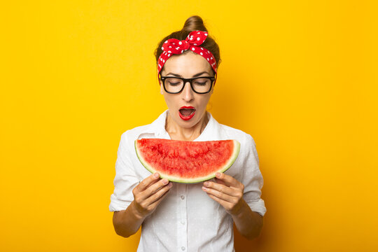 Young Woman With A Smile In A Red Headband And Glasses Eats Watermelon On A Yellow Background