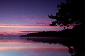 Fototapeta na wymiar 夜明けの湖畔の木と森の影。