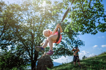 Real happy summertime. Girl flying on a swing in the mountains far from people, outdoor