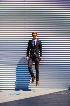 Handsome Businessman Jumping In Front a Modern Building