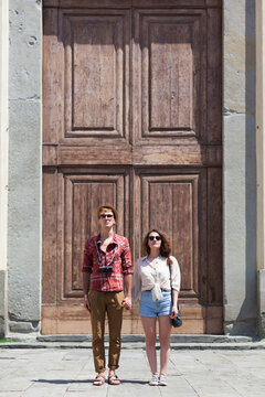 Young Couple Standing In Front of a Church Gate in Piazza Santo Spirito Florence. Tuscany Italy