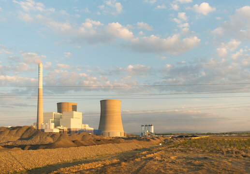 Chimney of power station on field under blue sky