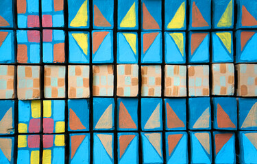 The wall background pattern is blue alternating with yellow and red.