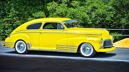 Close-up of a bright yellow colored beautiful sedan sports car from the 40's, seen around Vancouver, Canada, Northern America. No people present.