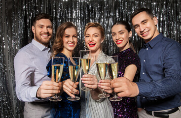 celebration and holidays concept - happy friends clinking champagne glasses at party