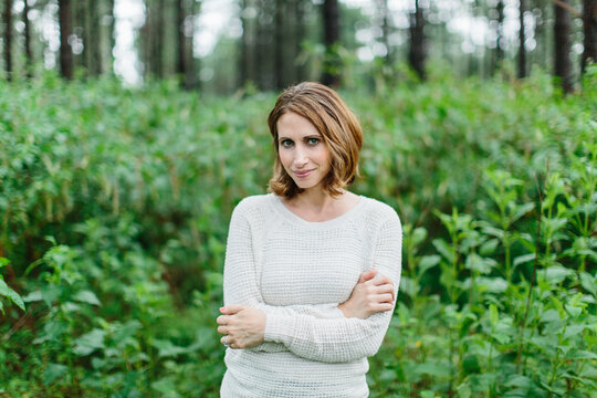 Portrait of a beautiful and fashionable woman standing in forrest
