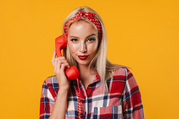 Image of pleased beautiful pinup girl posing with handset