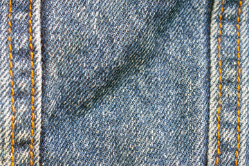 blue denim background on the sides with seams of brown threads