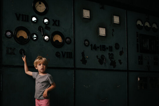 Boy pulls lever in disused power station.