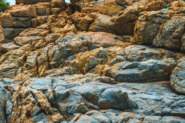 Close up view bright vivid orange brown yellow stone rock shabby cliff cracks texture mountains. Concept of geology, beauty power in nature. Natural summer composition landmark background design