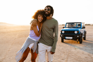 Image of african american couple walking while travelling with car