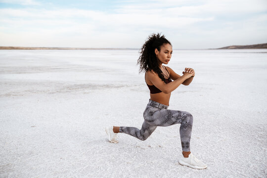 Image of african american sportswoman doing exercise while working out