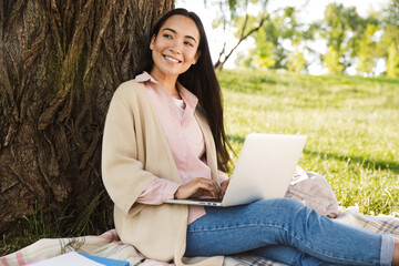 Beautiful young asian woman studying at the park,