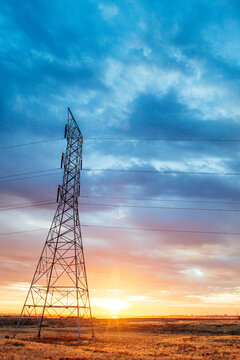 Power line transmission tower and electrical wires at sunrise in California's Central Valley