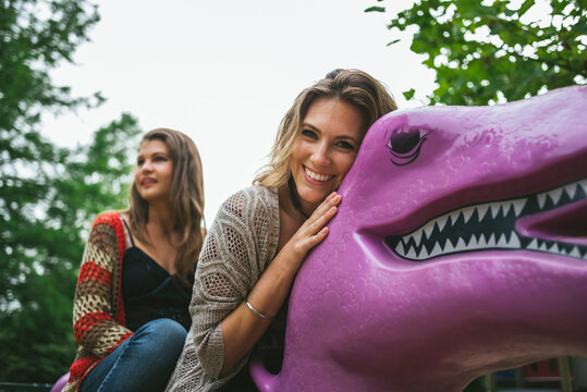 Young and free friends having fun on a T Rex in the park