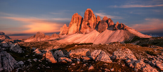 Fototapeta premium Fantastic mountain landscape at sunset. Majestic Tre cime di lavaredo peaks with colorful sky. Dolomites Alps. Tre Cime di Lavaredo national park. Popular travel and hiking Destination in the world.