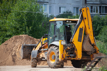 Fototapeta na wymiar An excavator at a construction site loads sand.