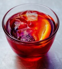 Negroni cocktail with ice cubes and garnished with a slice of orange
