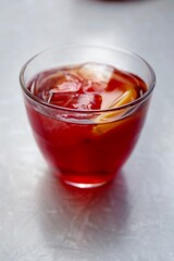 Negroni cocktail with ice cubes and garnished with a slice of orange