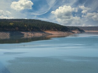 Fototapeta premium Koprinka Dam, Bulgaria in autumn. Its water has decreased. You can see its bottom.