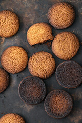 Burnt cookies. Burnt, burnt oatmeal cookies lie on a black baking sheet. Vertical photo