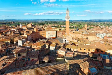 Obraz premium Aerial panorama of Siena, a beautiful medieval town in Tuscany Italy, with the famous landmark Mangia Tower ( Torre del Mangia ) standing tall by town square ( Piazza del Campo ) in city center