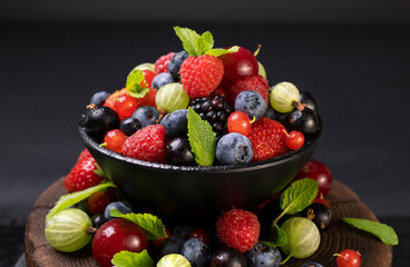 Mix of wild berries on black background