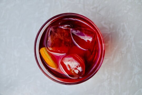 From Above View Of A Bright Red Negroni Cocktail With Ice Cubes And Garnished With An Orange Slice