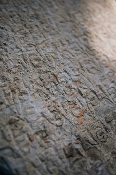Stones with details of ancient buddhist manuscript near a monastery, Nepal.