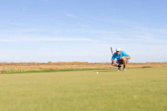 Man playing golf on a sunny day on a beautiful golf course