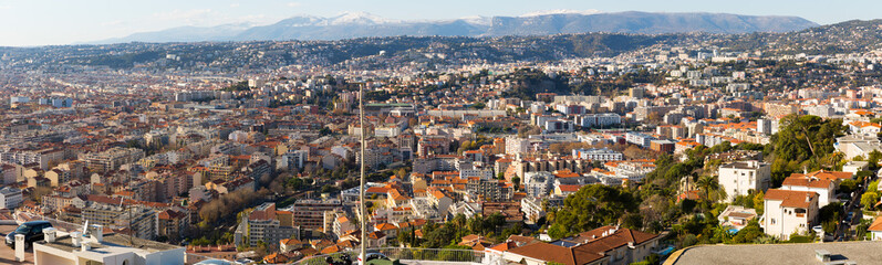 Scenic cityscape of French city of Nice on background of snowy Alps.