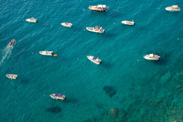 Aerial view of a group of small boats anchored near a small cove in the Gulf of Naples near Positano, Italy