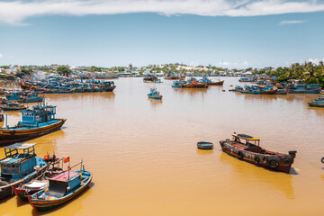Fototapeta na wymiar Traditional Vietnamese boats by yellow brown water in canal. 