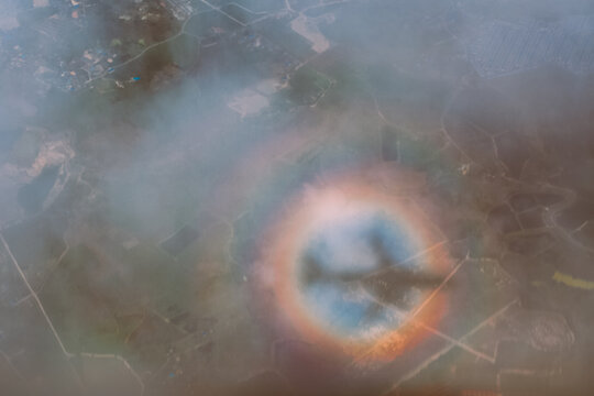 Airplane Shadow Within a Rainbow in the Clouds