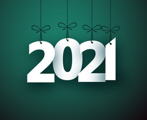 2021 paper sign hanging on ribbon on green background.