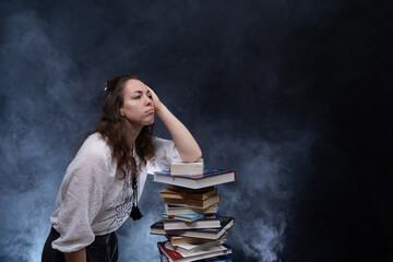 Sad female student reading with lots of books for the exam. Concept home education.