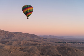 Fototapeta na wymiar Hot air Balloon over Valley of the King in Luxor city in a beautiful morning sunrise, Upper Egypt
