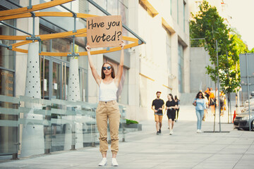 Have you voted. Dude with sign - woman stands protesting things that annoy her. Solo demonstration...