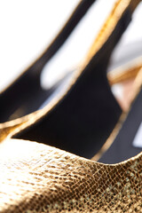 Close-up of a fragment of beautiful women's elegant open summer shoes made of gold leather with high heels. Selective focus.