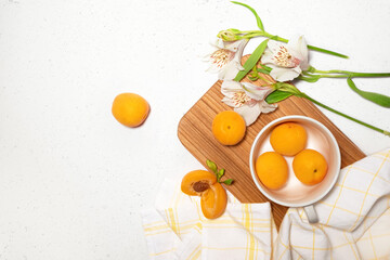 Apricot composition with wooden desk, white flowers, kitchen towel on white concrete background. Culinary web banner. Flatlay. Space for text. Place for text. High quality photo