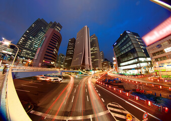 Fototapeta na wymiar Beautiful scenery of Tokyo Downtown at rush hour, with view of traffic light trails on busy streets and modern high rise office towers under blue twilight in background in Shinjuku, Tokyo, Japan