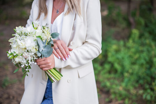 Wedding bouquet in bride hands. Roses, eustoma, eucalyptus in elegant bouquet. Summer and autumn flowers.