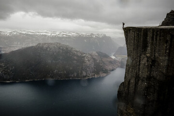 A hiker on the edge at Pulpit Rock (Preikestolen) in Norway