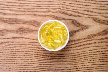 Fish oil pills on the wooden table.