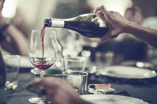 Serving red wine at a party with friends