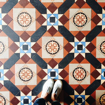 Feet standing on a victorian tiled floor