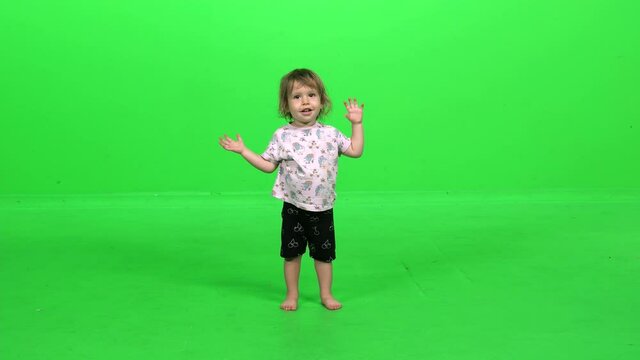 Adorable toddler girl playing a bird, a monkey and a fish, over green screen.
