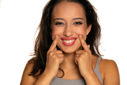 Young Dark Skinned Woman Forcing Her Smile With Her Fingers