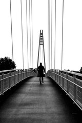 Suspension bridge and a man riding a scooter